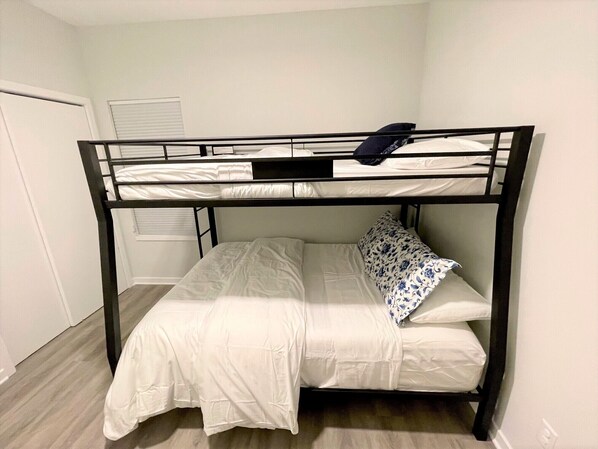 A bunk bed with white bedding and a blue floral pillow. - Modern Beach Home with Golf Cart! Dog Friendly! (Carolina Beach)