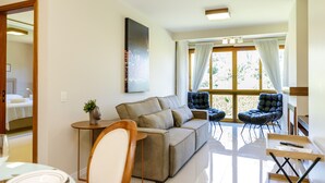 Un salon moderne comprenant un canapé, deux fauteuils, une table basse et un coin repas avec une table et des chaises.