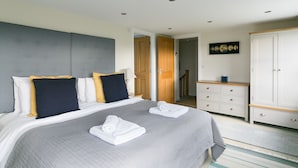 A neatly arranged bedroom with a large bed, a dresser, and a wardrobe.