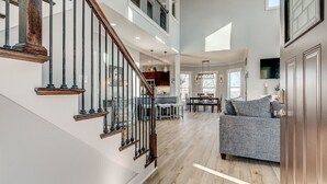 Un grand espace de vie comprenant un escalier, un coin repas et une cuisine.