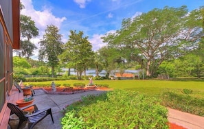 A patio area with outdoor seating, a small garden, and a view of a lake. - Cabin On The Lake (Lake Helen)