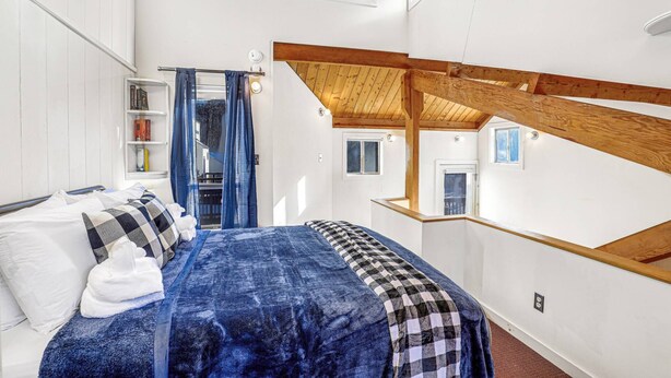 A bedroom with a bed, a bookshelf, and a window. - Happy Haven (Thornton)