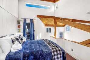 A bedroom with a bed, a bookshelf, and a window. - Happy Haven (Thornton)