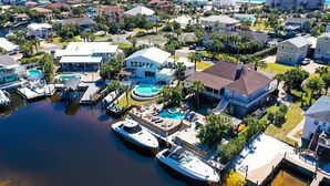 Una zona residencial costera con casas, un puerto deportivo y una piscina.