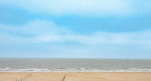Une plage avec un ciel dégagé et une mer calme.