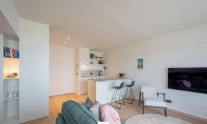 A modern apartment with a kitchen, dining area, and living room.