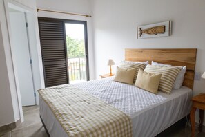 Ein Schlafzimmer mit einem großen Bett, einem Holzkopfende und einem Fenster mit Jalousien.