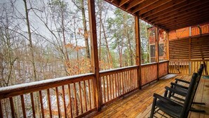 A wooden deck with a railing, wooden benches, and a view of trees. - Ridge resort getaway cabin, 2 Bds, 3 Ba, Pigeon Forge, Smoky Mountains (Pigeon Forge)
