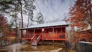 A wooden cabin with a balcony and a staircase leading to the entrance. - Ridge resort getaway cabin, 2 Bds, 3 Ba, Pigeon Forge, Smoky Mountains (Pigeon Forge)