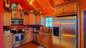 A modern kitchen with wooden cabinets, stainless steel appliances, and a large refrigerator. - Ridge resort getaway cabin, 2 Bds, 3 Ba, Pigeon Forge, Smoky Mountains (Pigeon Forge)