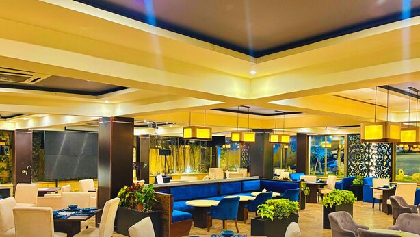 En moderne hotellobby med siddeområder, en receptionsdisk og store vinduer.