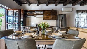 A modern kitchen with wooden cabinets, a dining table set for six, and a built-in oven.