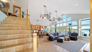 A spacious living area with a large sectional sofa, a fireplace, and a view of the outdoors.