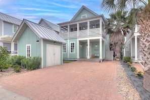 A two-story house with a covered porch and a garage. - Sunset Bay 111 ST (Port Aransas)