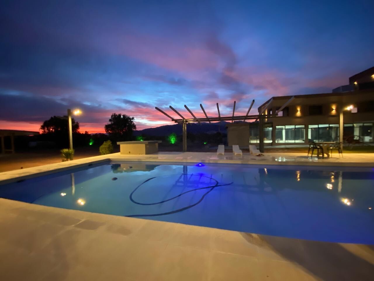 A swimming pool with a clear sky at dusk.