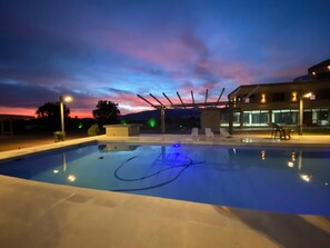 A swimming pool with a clear sky at dusk.