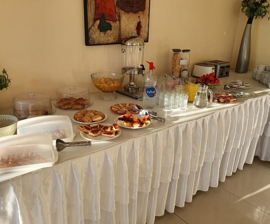 En buffet med forskellige spisemuligheder, en kaffemaskine og en vanddispenser.