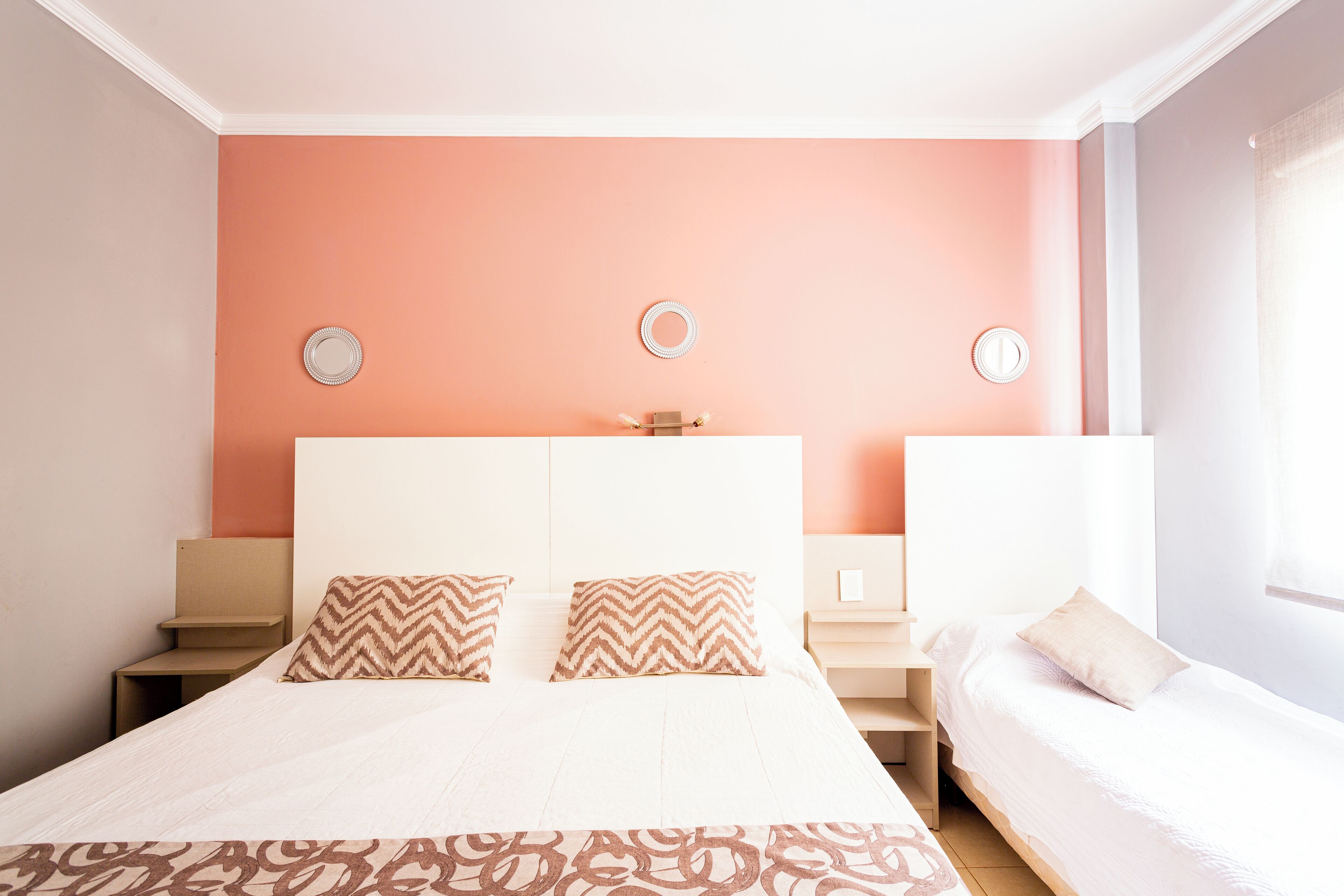 A bedroom with a large bed, two bedside tables, and a smaller bed.
