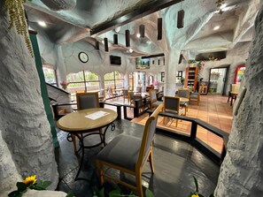 Un restaurante con paredes de piedra, muebles de madera y un reloj en la pared.
