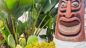 Uma estátua tiki cercada por plantas tropicais.