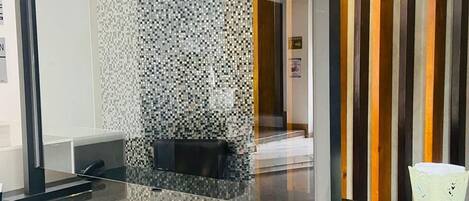 A reception area with a glass partition, a black countertop, and a decorative item on the counter.