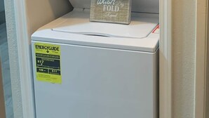 A compact washer and dryer unit with a ENERGY GUIDE sticker, placed in a corner with a small decorative item on top. - 😍GREAT LOCATION 2BD/1BTH UNIT W/ PVT BACKYARD 😍 (Puyallup)