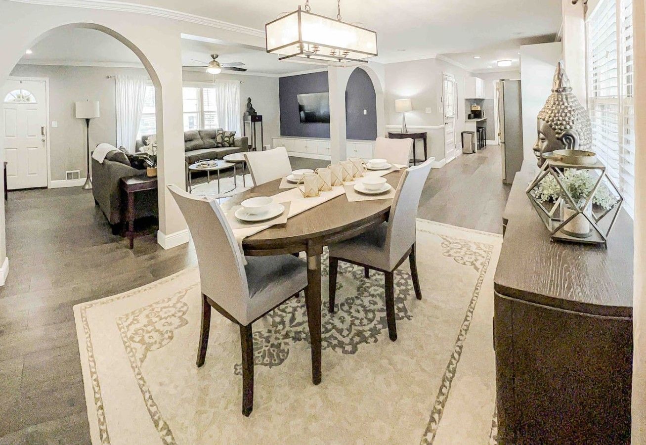 A dining area with a round table, chairs, and a decorative centerpiece.