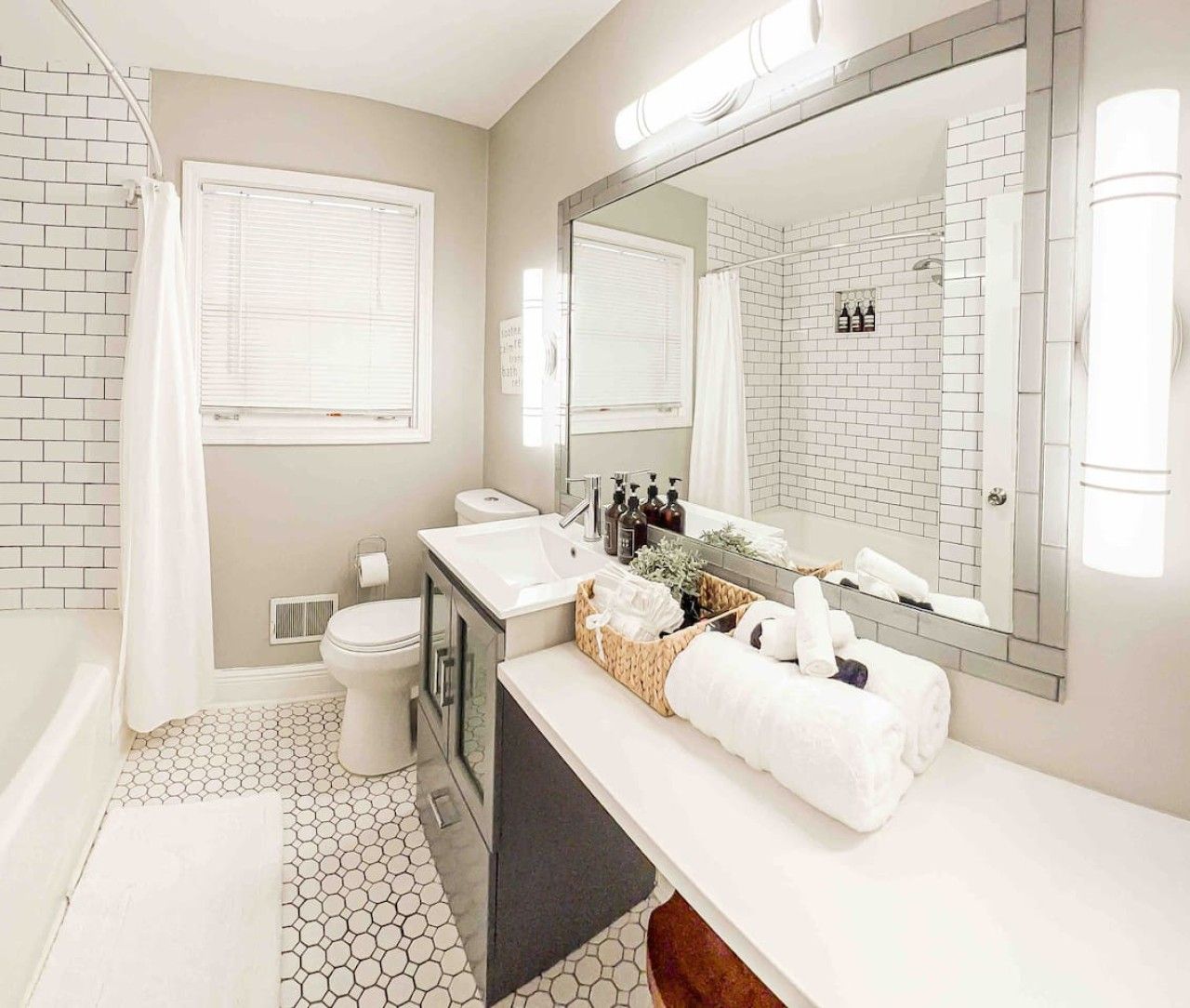 A bathroom with a toilet, sink, and mirror.