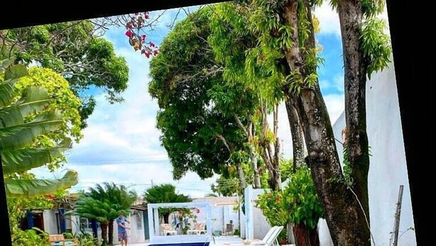 Zona d'estar a l'aire lliure amb piscina, arbres i vistes a la piscina.