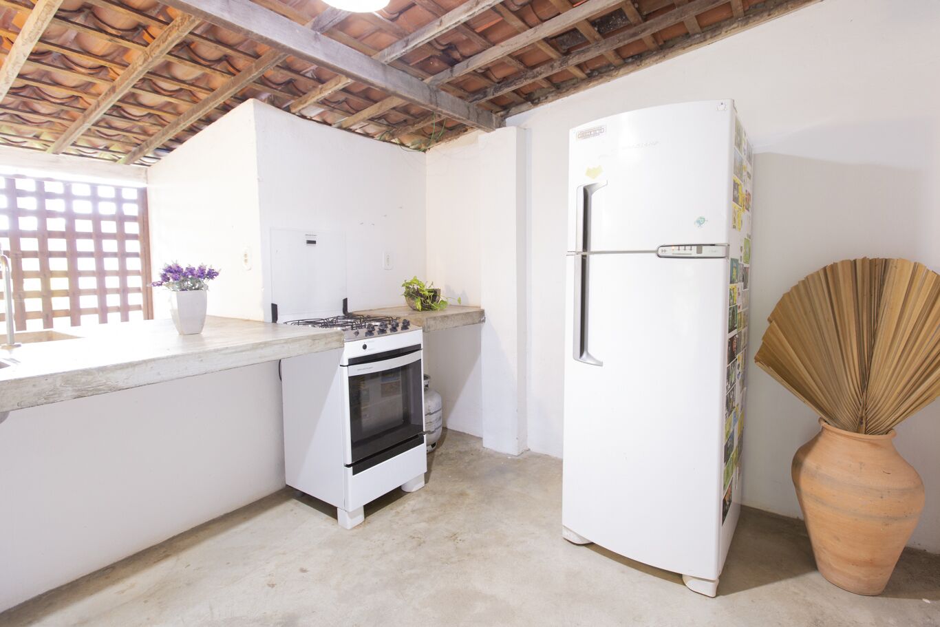 Una cocina compacta con estufa a gas, horno y refrigerador blanco.