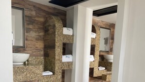 Un baño moderno con paneles de madera, un espejo grande y dos lavamanos.