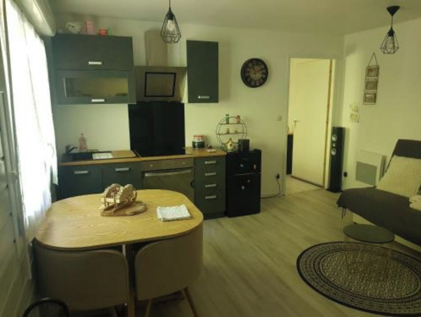 En kompakt bolig med tekøkken, spiseplads og en lille siddekrog.