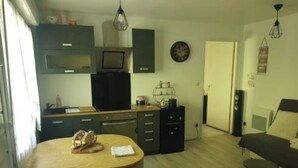 A compact living space with a kitchen, dining area, and a small seating area.