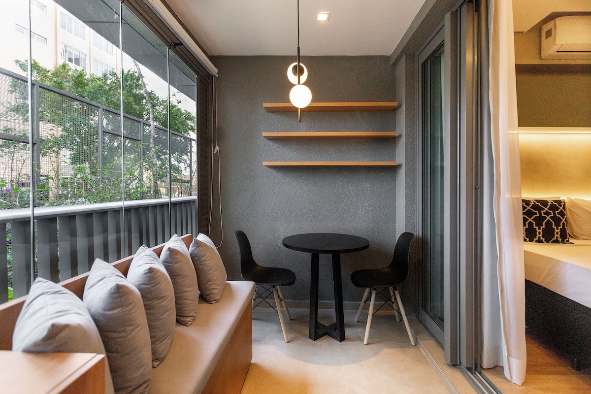 Una habitación moderna con sofá, dos sillones, una mesita y una lámpara colgante.