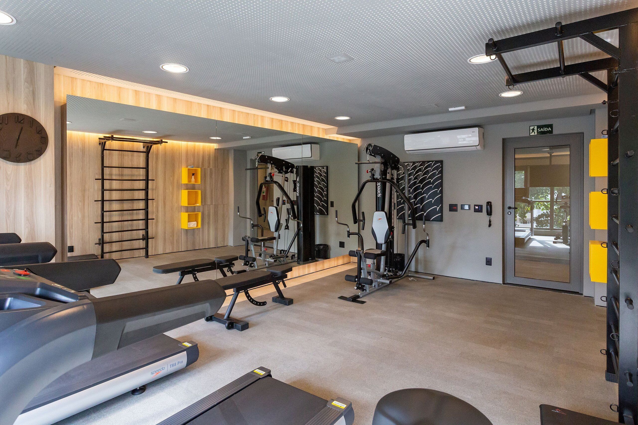 A gym with treadmills, benches, and various exercise machines.
