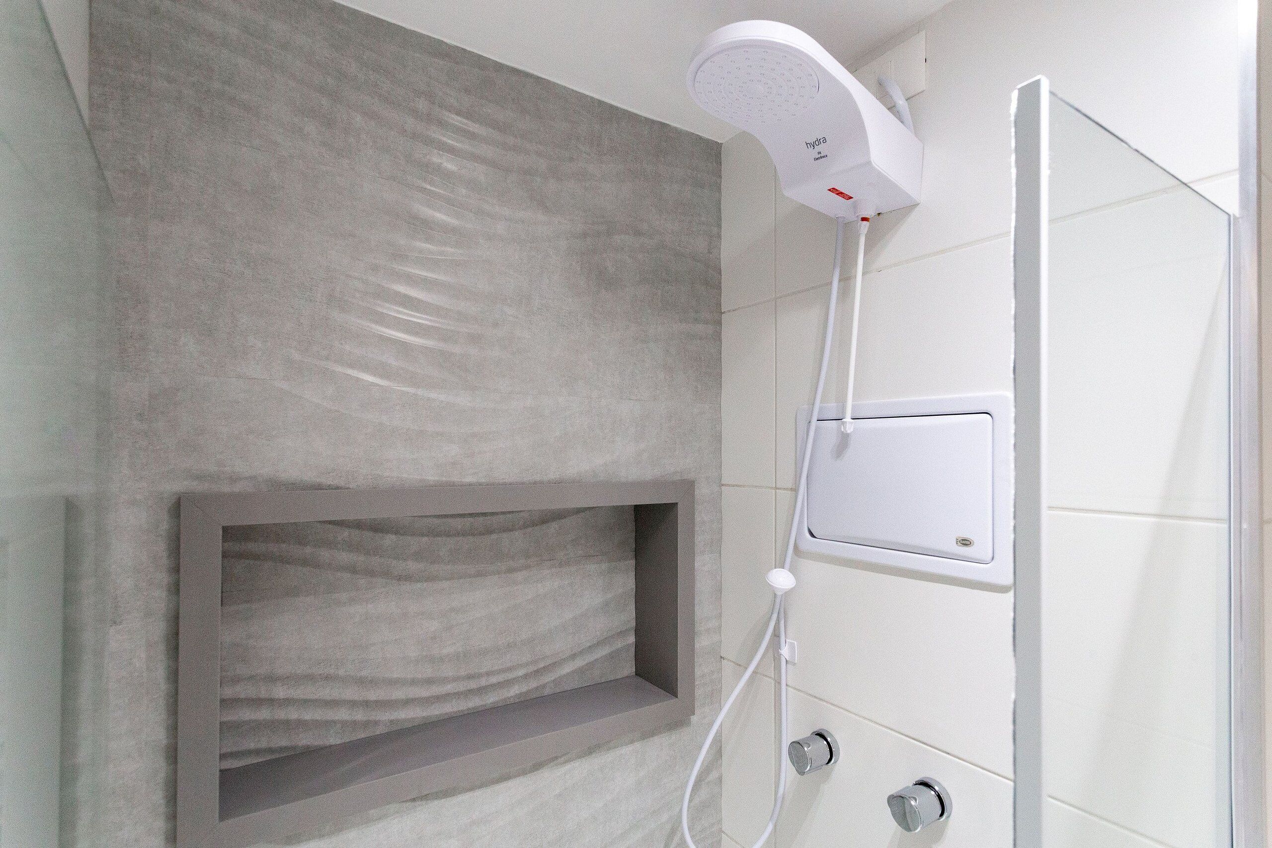 Ein modernes Badezimmer mit integrierter Dusche, einem Handtuchhalter und einer an der Wand befestigten Bedienkonsole.