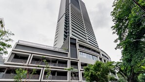 Un edificio moderno de gran altura con varios balcones y una fachada curva.