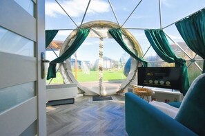 Une pièce circulaire offrant une vue panoramique, dotée d’un panneau de contrôle et d’un espace salon.