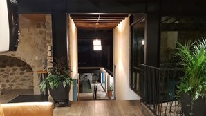 Una sala de estar moderna con chimenea de piedra, sofá de cuero y plantas en macetas.