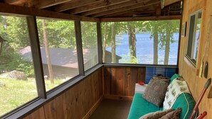 Una cabaña de madera con vistas a un lago y árboles.