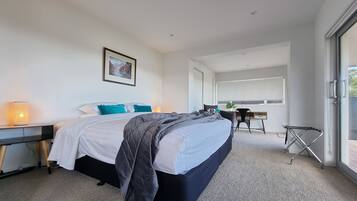 Quarto de hotel moderno com uma cama grande, uma escrivaninha e uma janela com vista.
