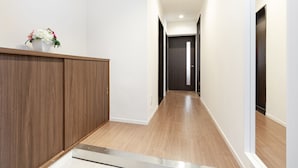 Un pasillo con paneles de madera en un lado, una pared blanca en el otro y suelo de madera.