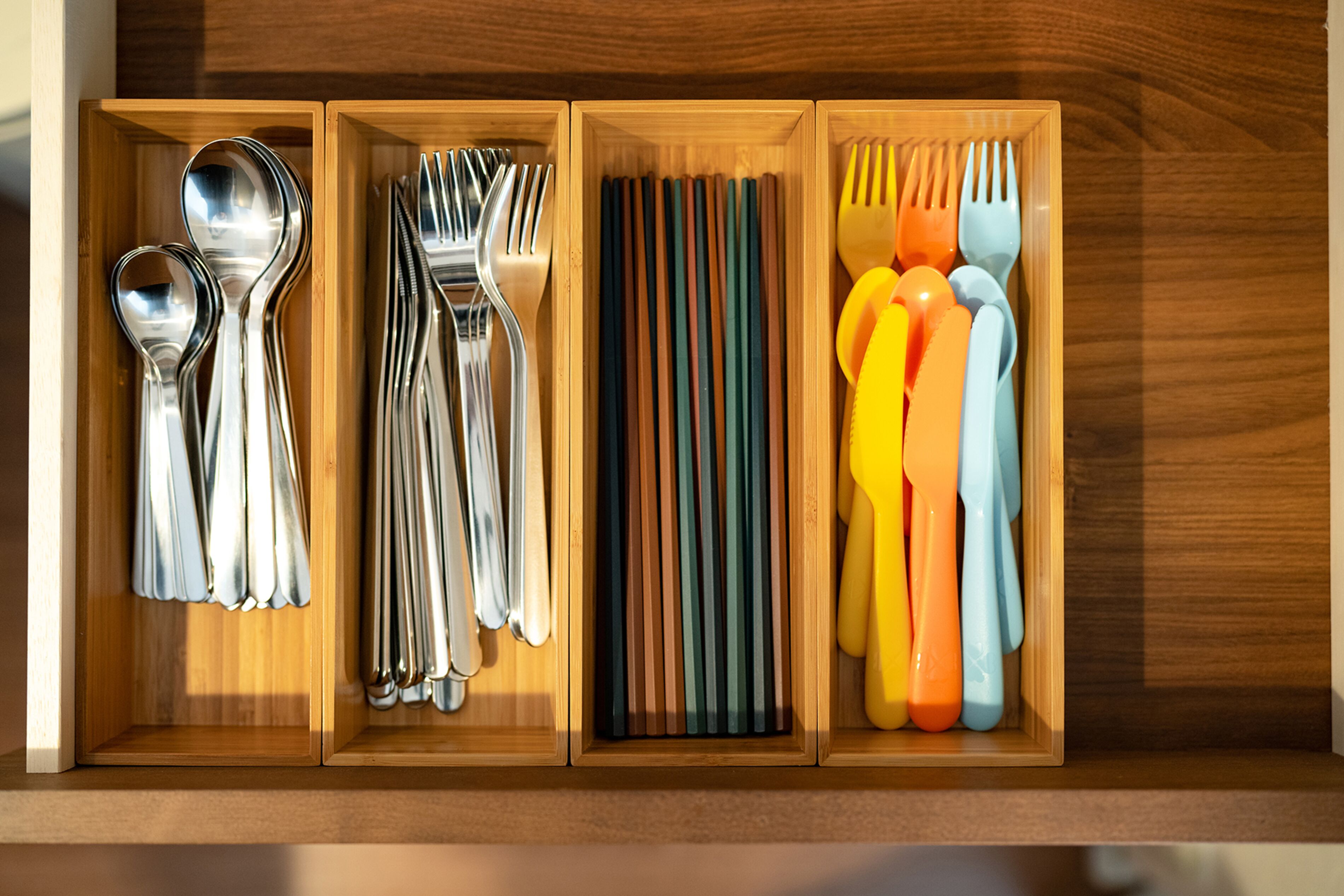 Un mueble de madera con tres compartimentos que contiene varios utensilios.