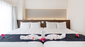 Cama doble con cabecera oscura y ropa de cama blanca, un panel de madera sobre la cama y una ventana con cortinas blancas.