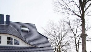 A house with a red exterior, a covered patio with outdoor furniture, and a well-maintained lawn. - Semi-detached house - Isabella - Bright vacation home spread over 3 floors with (Zingst)