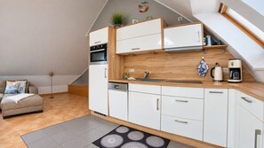 A modern kitchen with white cabinets, a wooden countertop, and a built-in oven. - Apartment Jonathan - Modern equipped apartment near the center! (Zingst)