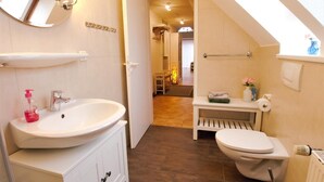 A compact bathroom with a sink, toilet, and a small vanity. - Apartment Jonathan - Modern equipped apartment near the center! (Zingst)