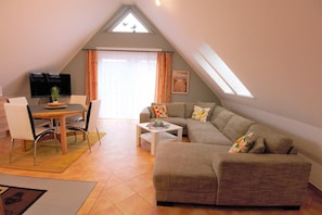 Un moderno loft con zona pranzo, divano e televisore.