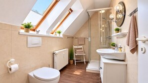 Une salle de bain moderne avec un puits de lumière, une douche, des toilettes et un lavabo.