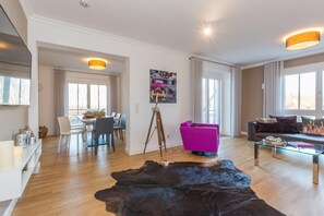 Una sala de estar moderna con comedor, un ventanal grande y una cámara instalada.